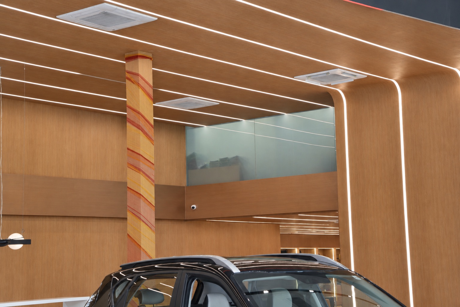 Wood-grain film surfaces and curved ceiling details in a KIA showroom