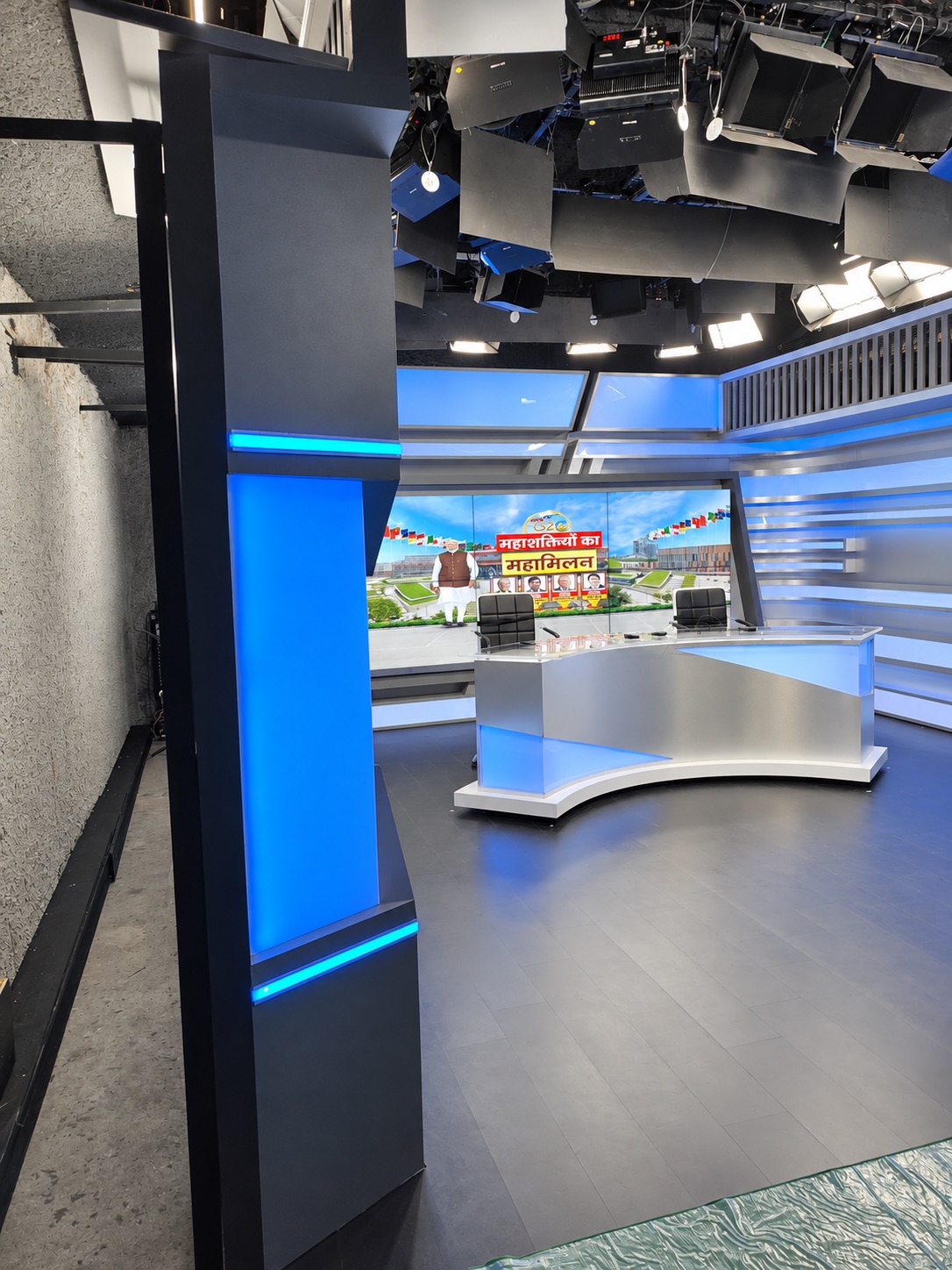 News studio interior with presentation desk and illuminated set elements.